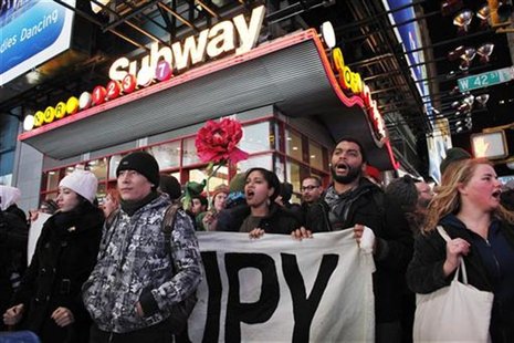 Protesters affiliated with the Occupy Wall Street movement hold a banner as they walk on the street during a protest in New York Protesters affiliated with the Occupy Wall Street movement hold a banner as they walk on the street during a protest in New York