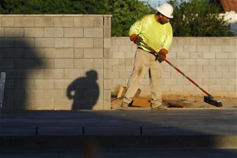 A worker sweeps the foundation of a house being constructed in Phoenix A worker sweeps the foundation of a house being constructed in Phoenix