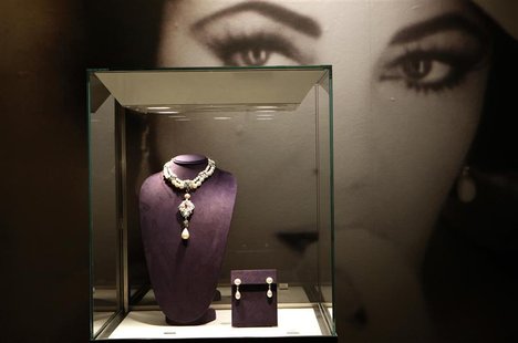 A photograph of Elizabeth Taylor is seen behind jewels on display as part of the upcoming auction at Christie's Auction house in New York A photograph of Elizabeth Taylor is seen behind jewels on display as part of the upcoming auction at Christie's Auction house in New York