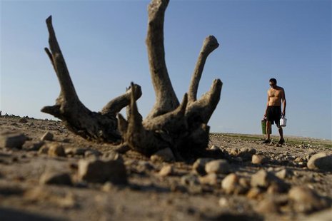 A man walks along Lake Travis after water receded during a drought in Austin, Texas A man walks along Lake Travis after water receded during a drought in Austin, Texas