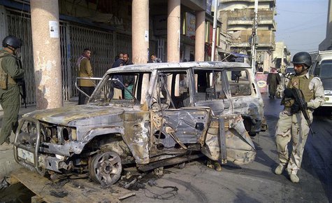 A soldier stands guard near a burnt vehicle after a bomb attack in Alawi district in central Baghdad A soldier stands guard near a burnt vehicle after a bomb attack in Alawi district in central Baghdad