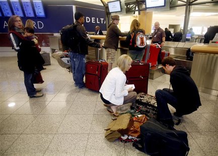 Holiday travelers check their bags at a Delta counter at Hartsfield-Jackson International Airport Holiday travelers check their bags at a Delta counter at Hartsfield-Jackson International Airport