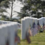 A visitor to Section 60 of Arlington National Cemetery near Washington places her hand on the headstone of a fallen soldier A visitor to Section 60 of Arlington National Cemetery near Washington places her hand on the headstone of a fallen soldier