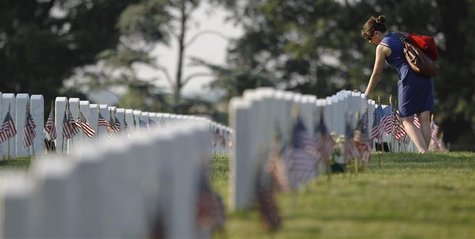A visitor to Section 60 of Arlington National Cemetery near Washington places her hand on the headstone of a fallen soldier A visitor to Section 60 of Arlington National Cemetery near Washington places her hand on the headstone of a fallen soldier