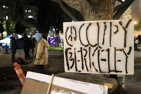 An Occupy Berkeley demonstrator walks past a sign at the movement's encampment after officials delivered an eviction notice in Berkeley An Occupy Berkeley demonstrator walks past a sign at the movement's encampment after officials delivered an eviction notice in Berkeley
