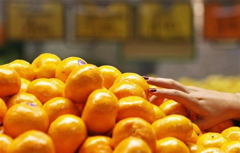 A woman picks up some mandarin oranges at a fruits shop in Sydney A woman picks up some mandarin oranges at a fruits shop in Sydney