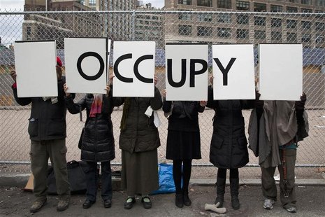 Protesters affiliated with the Occupy Wall Street movement stand with signs outside Duarte Square in New York Protesters affiliated with the Occupy Wall Street movement stand with signs outside Duarte Square in New York
