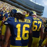 Denard Robinson and other Michigan players leave Michigan Stadium earlier this season.