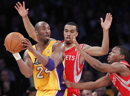 Los Angeles Lakers Kobe Bryant passes around Houston Rockets Courtney Lee and Kyle Lowry during their NBA game in Los Angeles Los Angeles Lakers Kobe Bryant passes around Houston Rockets Courtney Lee and Kyle Lowry during their NBA game in Los Angeles