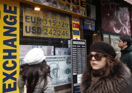 People walk past a currency exchange shop in Budapest People walk past a currency exchange shop in Budapest