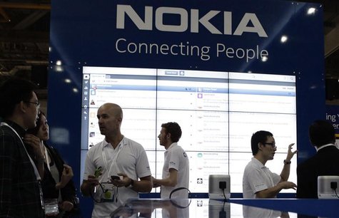 Staff members speak to trade visitors at the Nokia booth at the CommunicAsia expo in Singapore Staff members speak to trade visitors at the Nokia booth at the CommunicAsia expo in Singapore