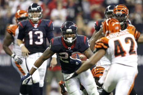 Houston Texans' Foster runs with the ball between Texans quarterback Yates and Cincinnati Bengals' Crocker in the third quarter during their Houston Texans' Foster runs with the ball between Texans quarterback Yates and Cincinnati Bengals' Crocker in the third quarter during their