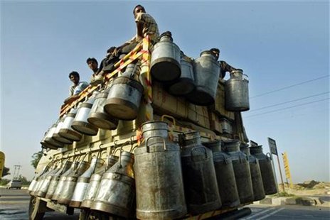Indian milkmen sit on top of a truck with milk containers in New Delhi Indian milkmen sit on top of a truck with milk containers in New Delhi