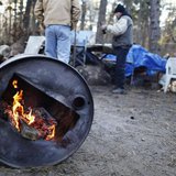 Two men talk while warming themselves by a fire in a homeless community near Lakewood, New Jersey Two men talk while warming themselves by a fire in a homeless community near Lakewood, New Jersey