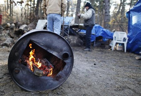 Two men talk while warming themselves by a fire in a homeless community near Lakewood, New Jersey Two men talk while warming themselves by a fire in a homeless community near Lakewood, New Jersey