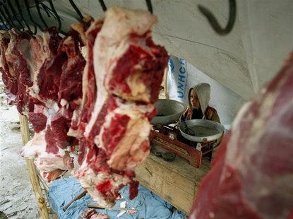 AN AFGHAN CHILD SELLS RAW MEAT ON A STREET IN KABUL. AN AFGHAN CHILD SELLS RAW MEAT ON A STREET IN KABUL.
