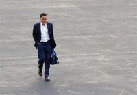 Republican presidential candidate and former Massachusetts Governor Mitt Romney walks across the tarmac to his campaign plane in Bedford