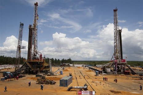 Employees work on drilling rigs at an oil well operated by Venezuela's state oil company PDVSA in Morichal