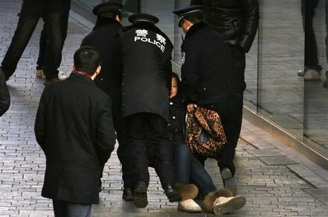 A woman is dragged away by police after she refused to leave from the front of the Apple store in the Beijing district of Sanlitun A woman is dragged away by police after she refused to leave from the front of the Apple store in the Beijing district of Sanlitun