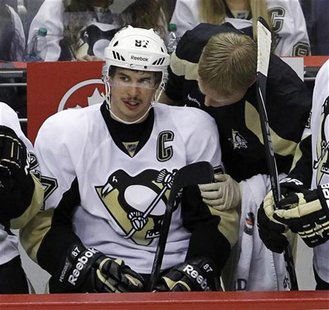 A trainer checks on Pittsburgh Penguins' Crosby during their NHL hockey game in Washington A trainer checks on Pittsburgh Penguins' Crosby during their NHL hockey game in Washington