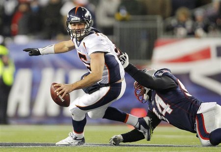 Denver Broncos quarterback Tim Tebow (L) is grabbed by New England Patriots defensive end Shaun Ellis in the third quarter of their NFL AFC Denver Broncos quarterback Tim Tebow (L) is grabbed by New England Patriots defensive end Shaun Ellis in the third quarter of their NFL AFC
