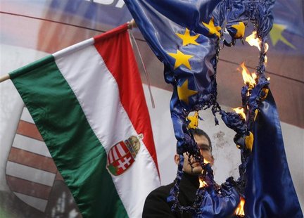 Elod Novak, parliamentary member of Hungarian far-right party Jobbik, burns an EU flag during a demonstration against the European Union, in Elod Novak, parliamentary member of Hungarian far-right party Jobbik, burns an EU flag during a demonstration against the European Union, in
