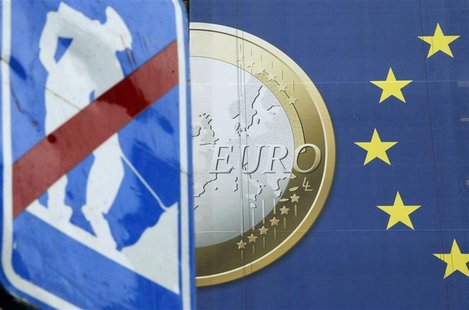 A road sign is seen near a banner of a euro coin on the facade of the European Commission headquarters in Brussels A road sign is seen near a banner of a euro coin on the facade of the European Commission headquarters in Brussels