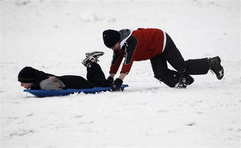 Seattle residents Moore pushes friend Clement on sled in Maple Leaf Park in Seattle. Seattle residents Moore pushes friend Clement on sled in Maple Leaf Park in Seattle.