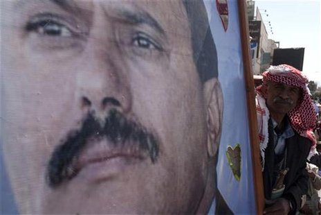 A supporter of Yemen's outgoing President Ali Abdullah Saleh holds his poster as they attend a rally to show support for Saleh in Sanaa A supporter of Yemen's outgoing President Ali Abdullah Saleh holds his poster as they attend a rally to show support for Saleh in Sanaa