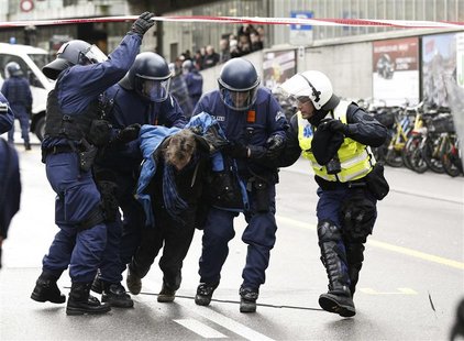 Swiss riot police remove an anti World Economic forum protestor during a demonstration in Bern