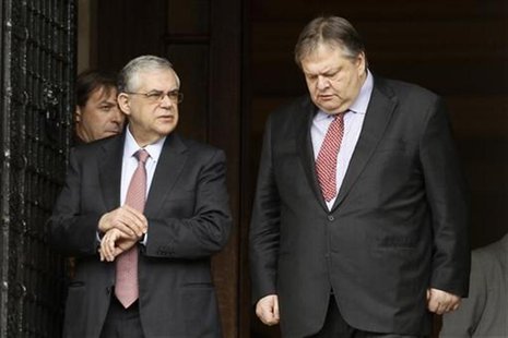 Greece's PM Papademos escorts Finance Minister Venizelos after a meeting in Athens