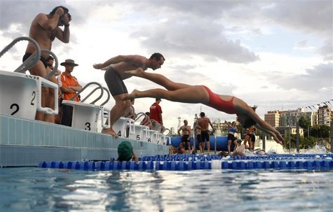 Participants jump into a swimming pool during a weekly, after-work biathlon at The Domain adjacent to Sydney's central business district Participants jump into a swimming pool during a weekly, after-work biathlon at The Domain adjacent to Sydney's central business district