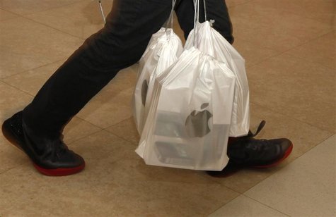 A man carries packs of Apple iPhone 4S, with each pack containing five sets, outside an Apple store in Hong Kong A man carries packs of Apple iPhone 4S, with each pack containing five sets, outside an Apple store in Hong Kong