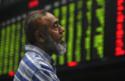 A trader monitors an electronic board displaying the index at the Karachi Stock Exchange A trader monitors an electronic board displaying the index at the Karachi Stock Exchange