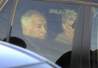 Former Penn State assistant football coach Jerry Sandusky sits in his car with his wife Dottie after departing from a preliminary hearing in