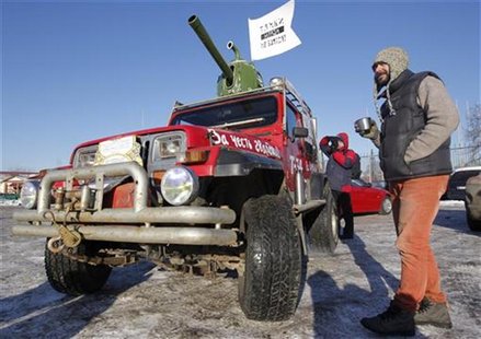 A participant stands near his car, which was modified to resemble a tank, before taking part in "The White Ring", a protest motor rally in M A participant stands near his car, which was modified to resemble a tank, before taking part in "The White Ring", a protest motor rally in M