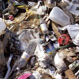 Trash awaits collection during a community trash collection event along the Santa Cruz River in Rio Rico