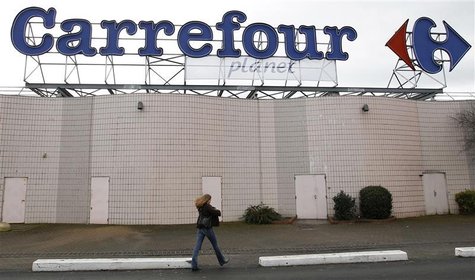 A woman walks below the logo of Carrefour Planet supermarket in Bordeaux A woman walks below the logo of Carrefour Planet supermarket in Bordeaux