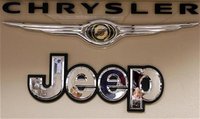 Pro Chrysler Jeep staff members are reflected in a sign at the Chrysler dealership during a meeting in Thornton