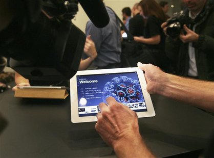 A man shows an example of an iBook textbook on an iPad after a news conference introducing a digital textbook service in New York A man shows an example of an iBook textbook on an iPad after a news conference introducing a digital textbook service in New York