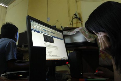 Sixteen year old Danieli Riva looks at her facebook page at a public internet service in Juan Pablo II shanty town in Villa El Salvador Sixteen year old Danieli Riva looks at her facebook page at a public internet service in Juan Pablo II shanty town in Villa El Salvador