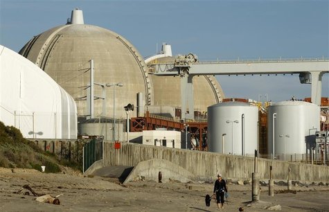 A woman and her dogs walk past the San Onofre Nuclear Generating Station that sits on the shore of the Pacific Ocean in North San Diego Coun A woman and her dogs walk past the San Onofre Nuclear Generating Station that sits on the shore of the Pacific Ocean in North San Diego Coun