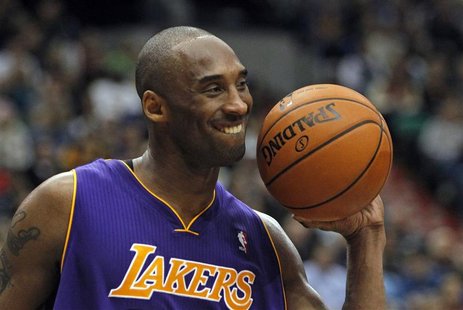 Los Angeles Lakers guard Kobe Bryant smiles as he hands the ball back to a referee in Minneapolis Los Angeles Lakers guard Kobe Bryant smiles as he hands the ball back to a referee in Minneapolis