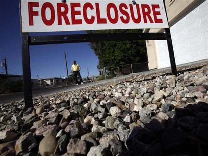 Realtor Mac McCollum stands in front of a foreclosed home in Bullhead City, Arizona Realtor Mac McCollum stands in front of a foreclosed home in Bullhead City, Arizona