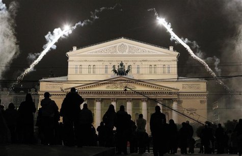 People look at the illuminated Bolshoi Theatre during its reopening ceremony in Moscow