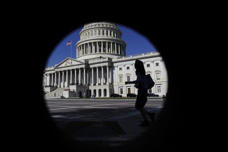 A woman walks past the U.S. Capitol dome, seen through a porthole in nearby brick-work, in Washington A woman walks past the U.S. Capitol dome, seen through a porthole in nearby brick-work, in Washington
