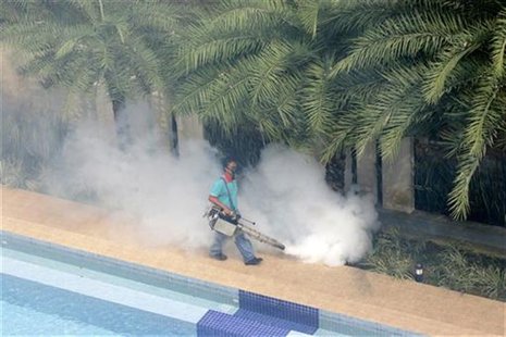 A worker 'fogs' in the public area of a private condominium in Singapore