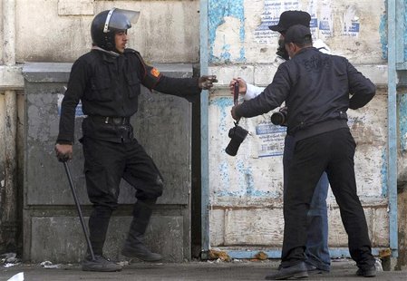 Egyptian security forces detain a press photographer during clashes near the Interior Ministry in Cairo