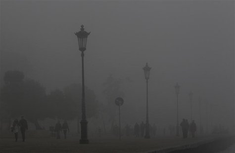 People walk on a promenade during a foggy day in Thessaloniki