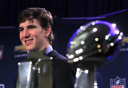 New York Giants quarterback Manning stands behind his Most Valuable Player trophy and the Vince Lombardi trophy the day after the NFL Super 